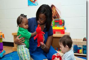 Woman in White Long Sleeve Shirt Playing with Baby